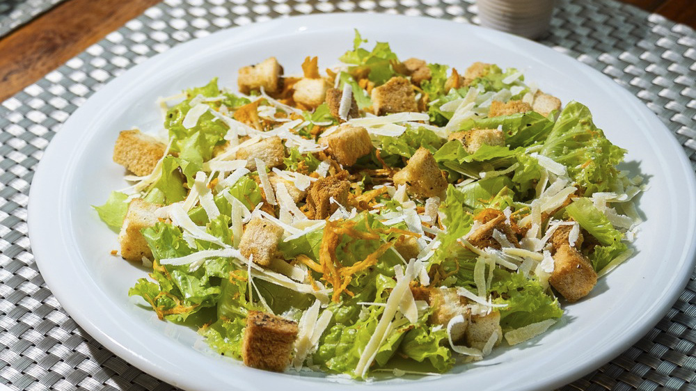 Salada Caesar com folhas verdes, croutons e lascas de parmesão em prato branco no Restaurante Planalto, em Rurópolis, Pará.