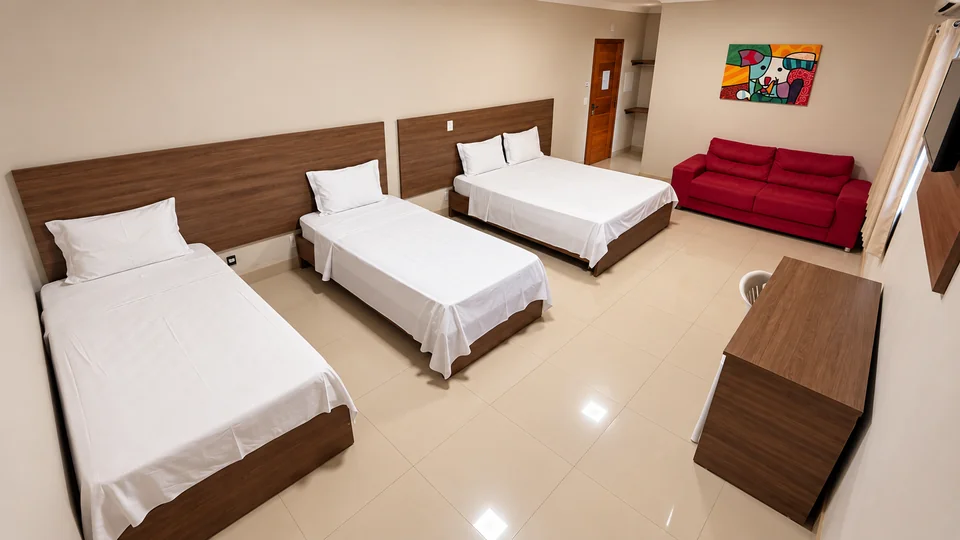 Suíte Família do Planalto Palace Hotel em Rurópolis, com cama de casal, duas camas de solteiro e sofá vermelho.